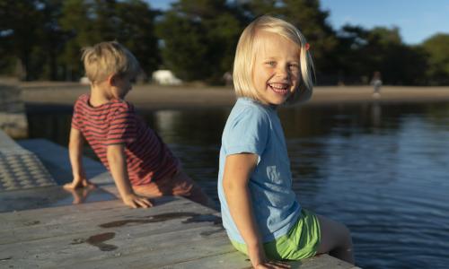 Barn som sitter vid bryggan i Stenö