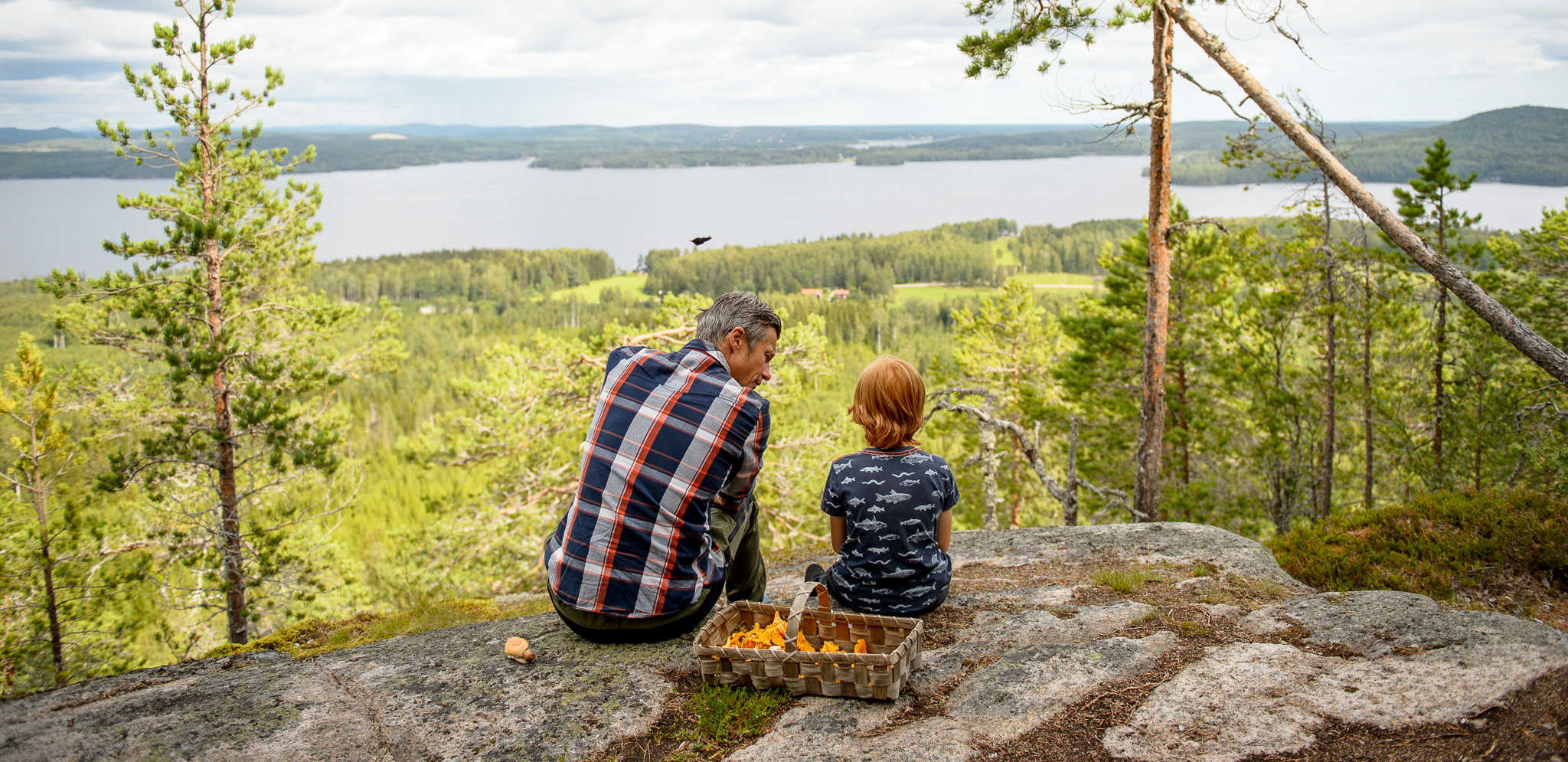 Två personer sitter och ser ut på den fina utsikten  från en utsiktsplats