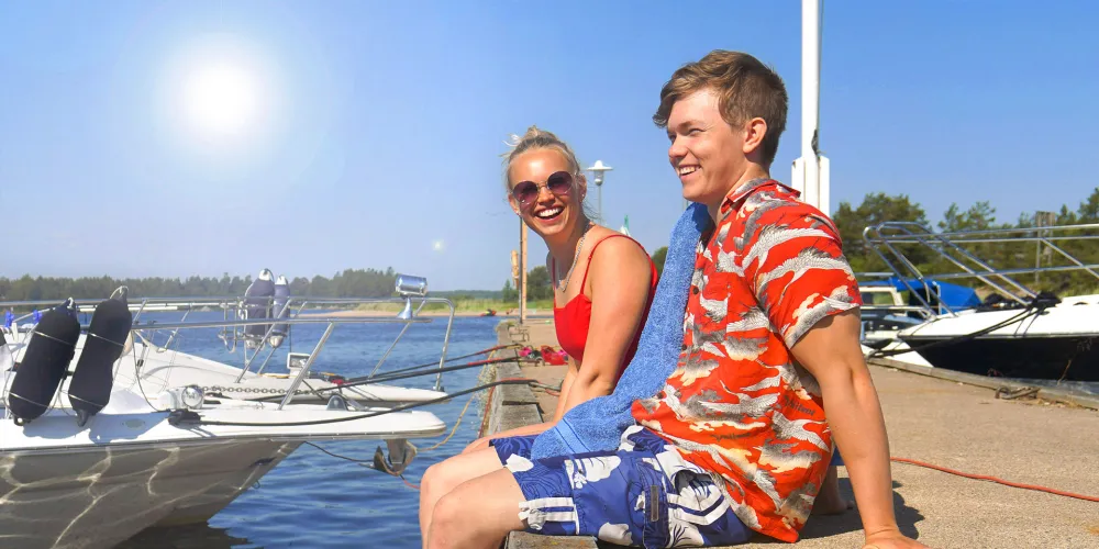 A young couple relaxing at the pier in Enskärsoren’s guest harbor.