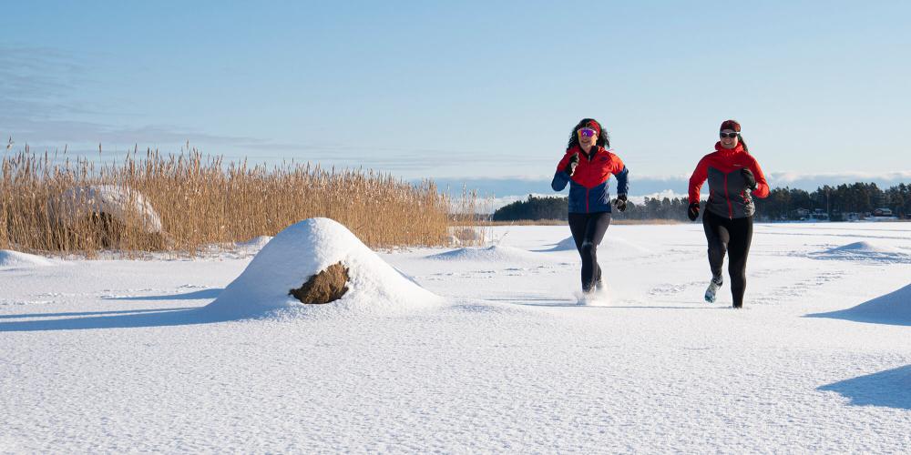 Två kvinnor som springer i vintern i Söderhamns skärgård