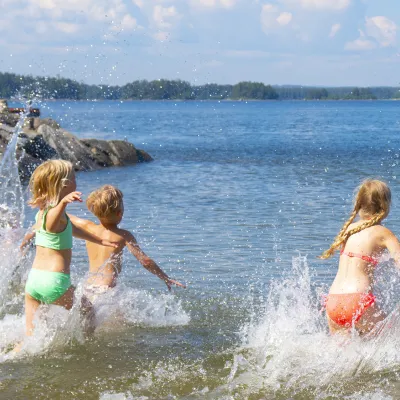 Barn som springer och badar i havet
