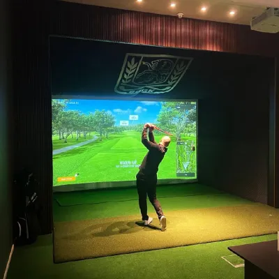 En person som slår ett slag i golfsimulator