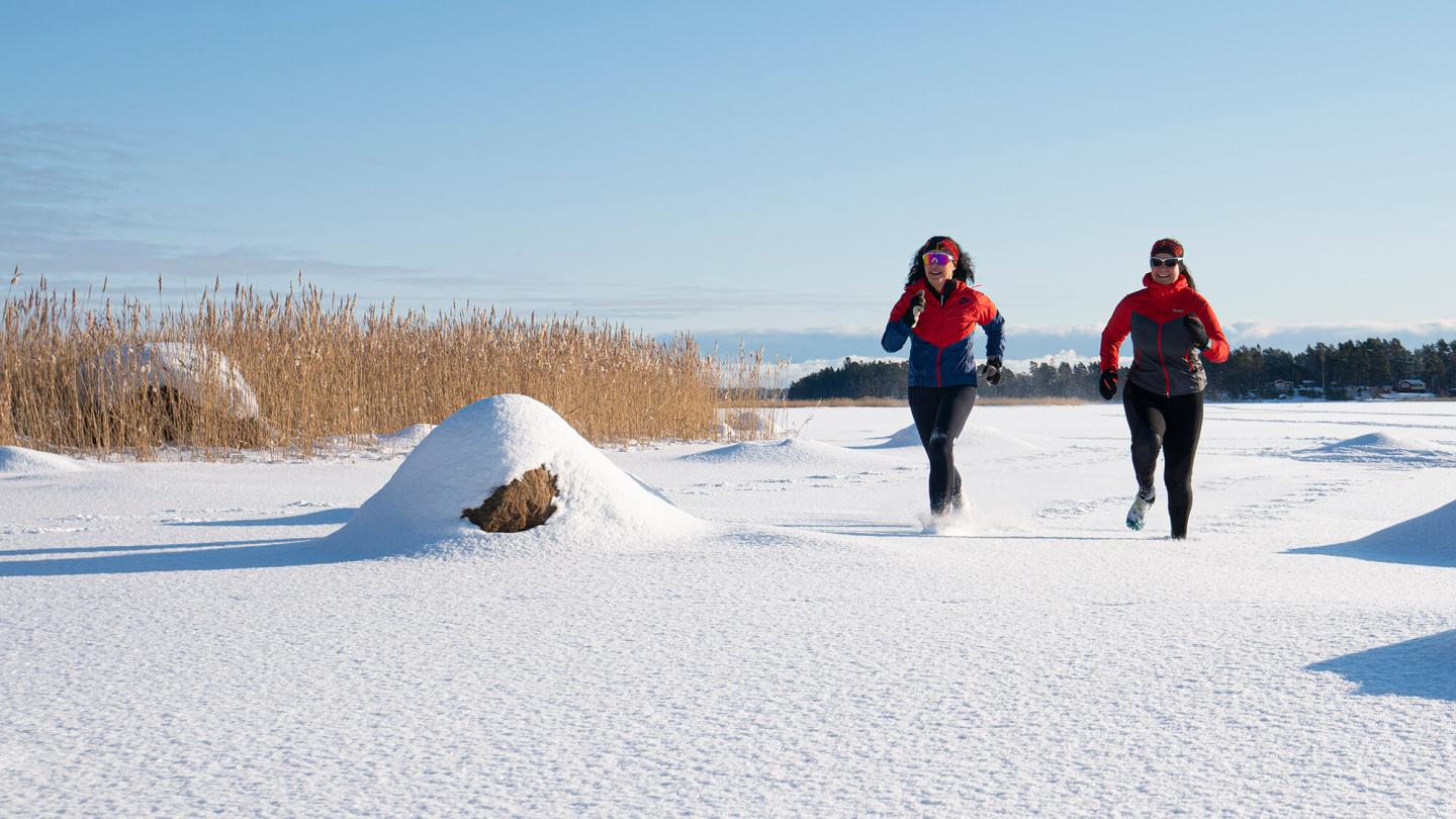 Två kvinnor som springer under vintern
