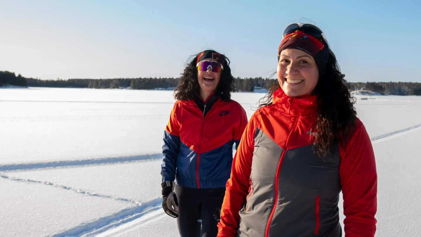 Glada kvinnor på vinterpromenad